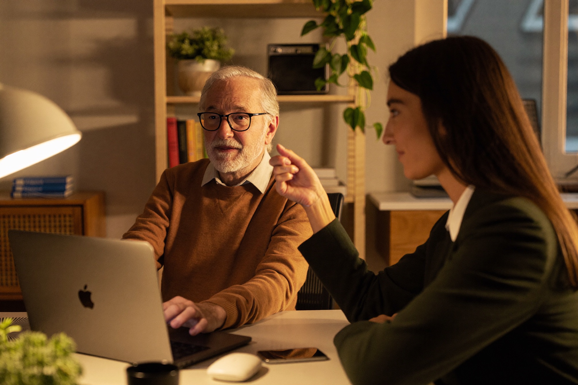 A private working session between two professionals in warm lamp light